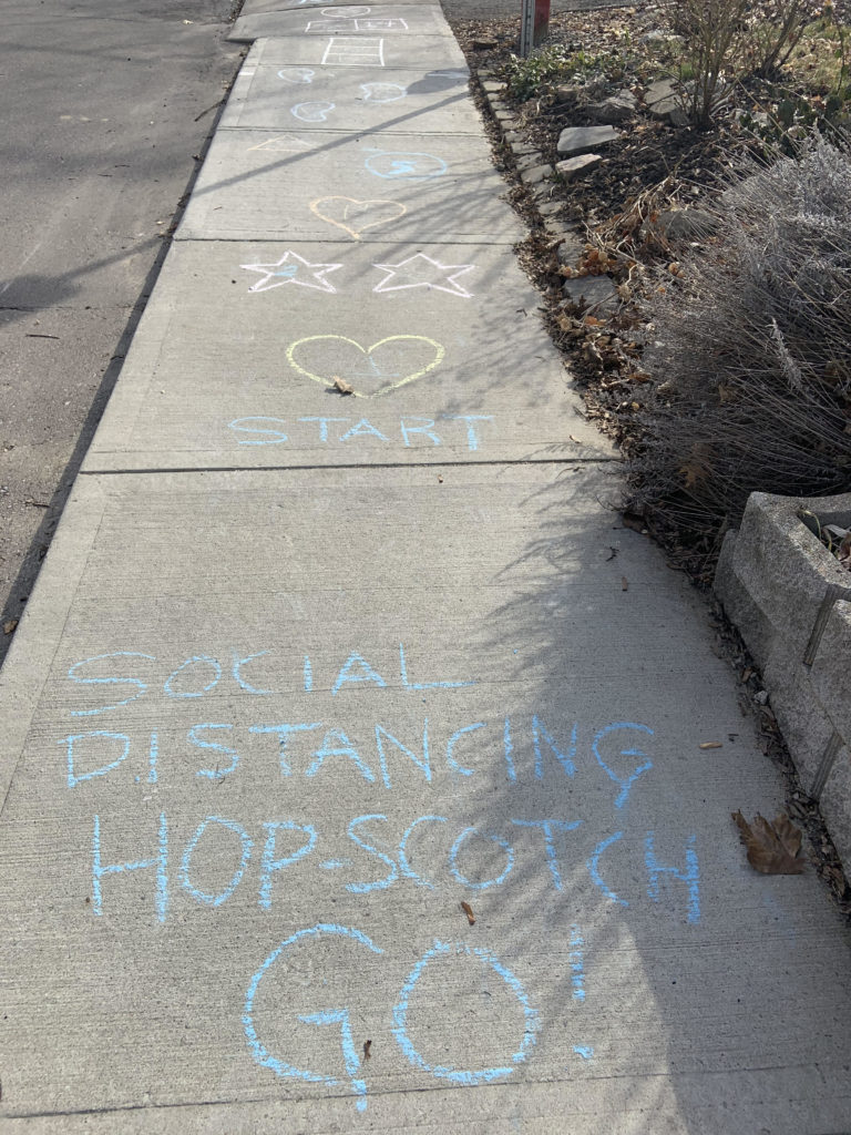 social distancing hopscotch; the image features a sidewalk with drawings that create a hopscotch activity 
